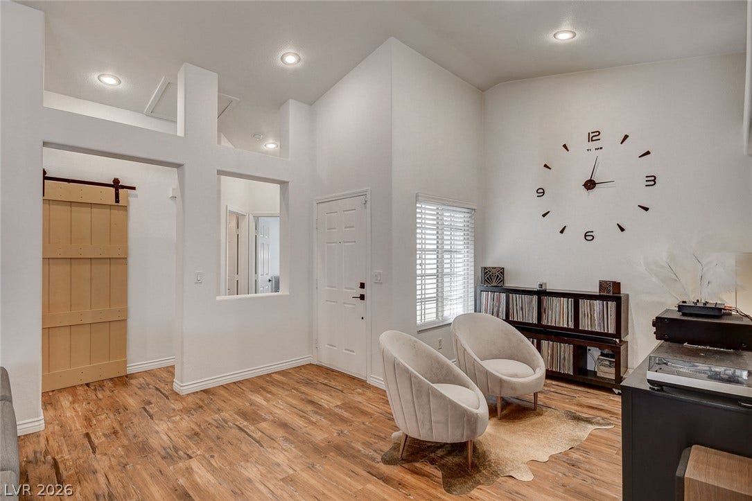 236 Misty Garden Street, Henderson, NV 89012 High vaulted ceilings and rich wood-look flooring anchor this versatile interior living space.