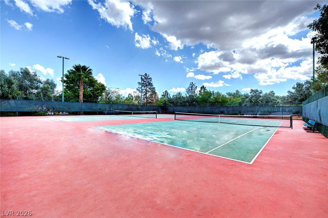 236 Misty Garden Street, Henderson, NV 89012 Fenced outdoor tennis courts offer a dedicated space for recreation beneath wide open skies.