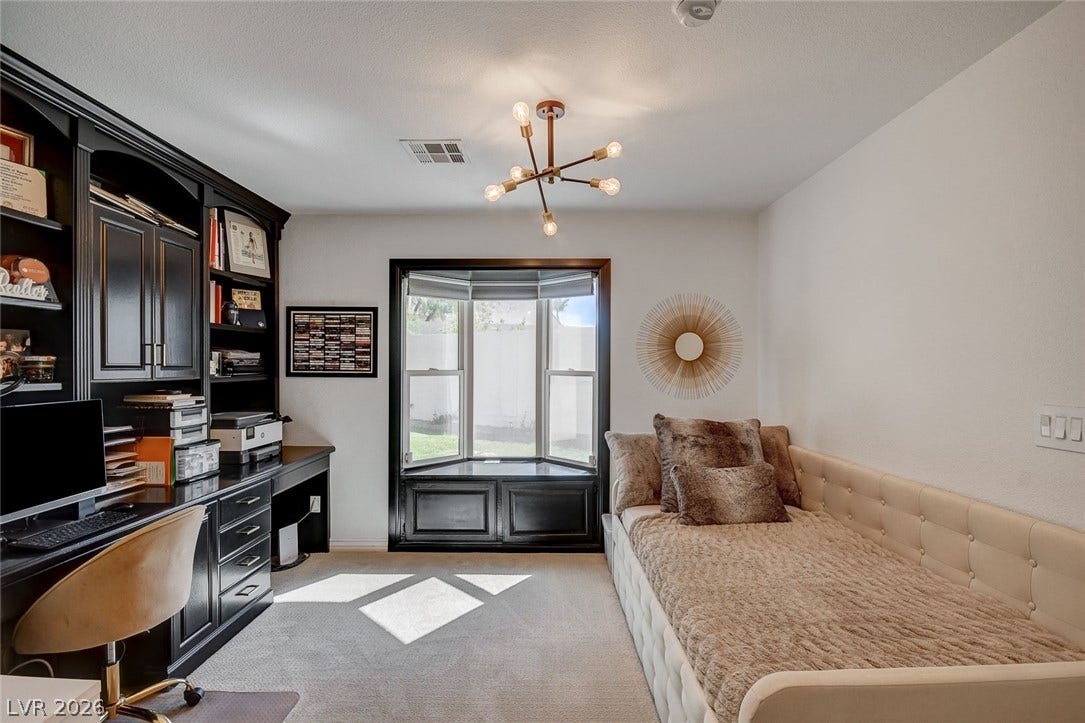 236 Misty Garden Street, Henderson, NV 89012 A spacious room features plush carpeting and a classic built-in desk under a bay window.