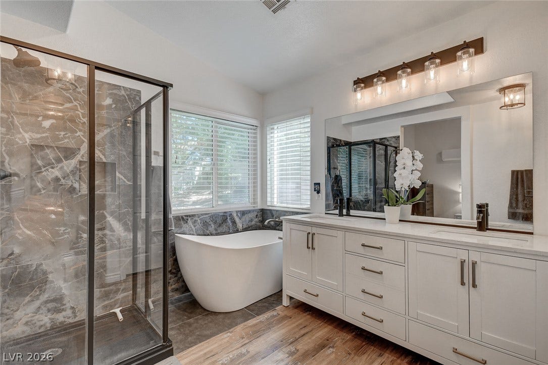 236 Misty Garden Street, Henderson, NV 89012 Hardwood floors and a freestanding soaking tub anchor this refined, modern bathroom space.