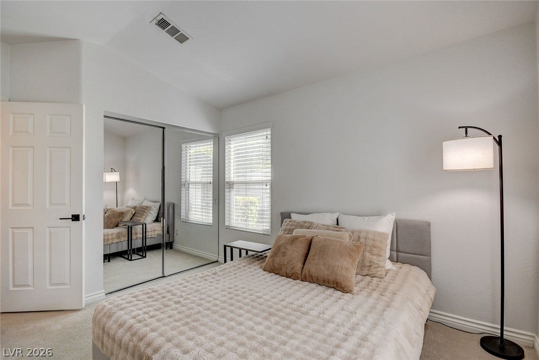 236 Misty Garden Street, Henderson, NV 89012 Plush carpeting anchors this bedroom featuring mirrored closet doors and a multi-pane window.