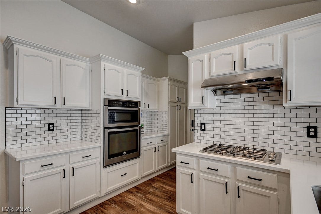 236 Misty Garden Street, Henderson, NV 89012 Crisp subway tile backsplashes complement the white cabinetry and modern built-in appliances.