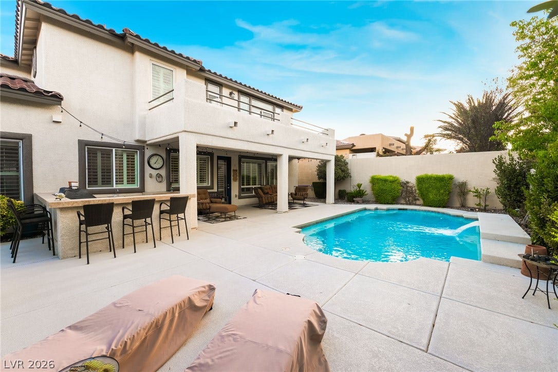 11416 Rancho Portena Avenue, Las Vegas, NV 89138 An inviting backyard oasis features a sparkling swimming pool, built-in bar, and covered patio.