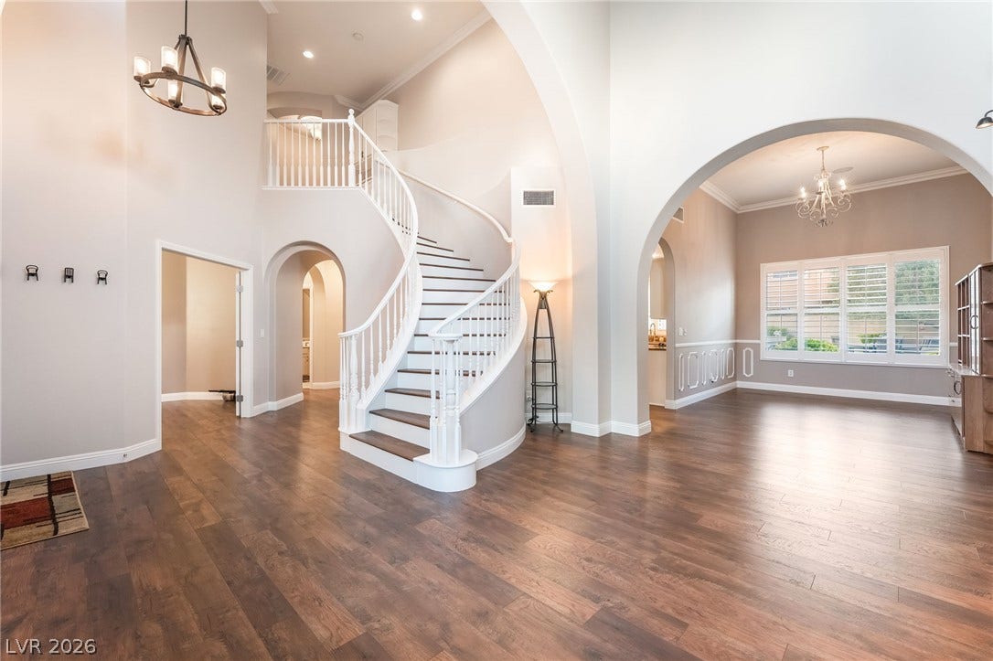 11416 Rancho Portena Avenue, Las Vegas, NV 89138 An elegant curved staircase anchors this open foyer featuring rich hardwood flooring and grand arched entries.