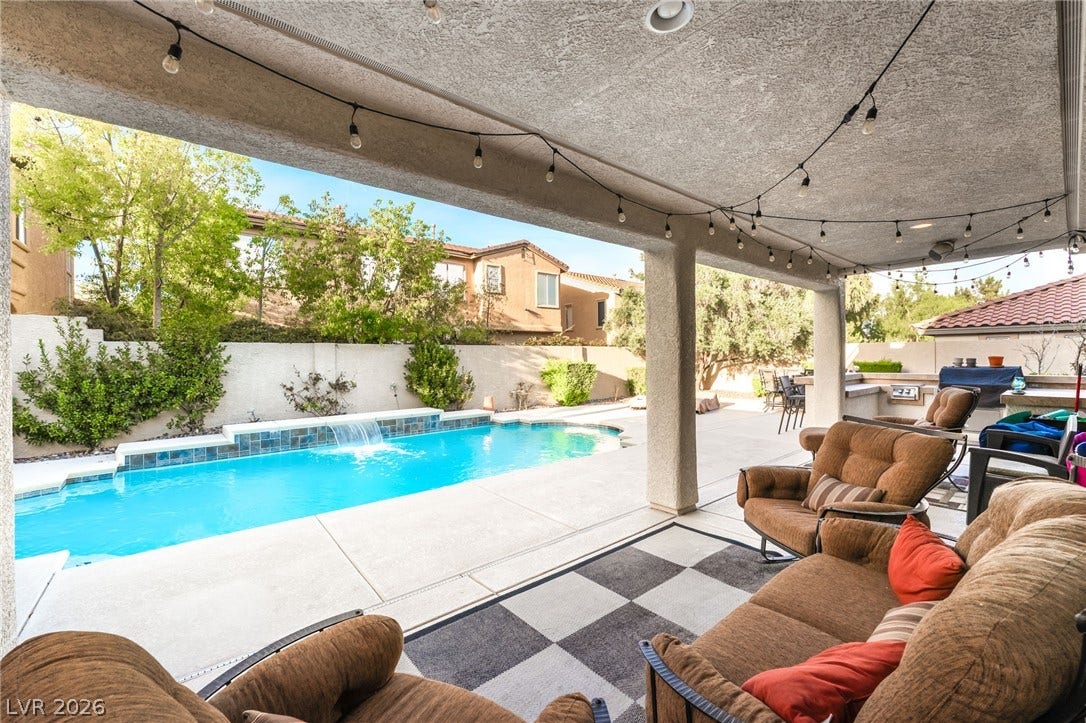 11416 Rancho Portena Avenue, Las Vegas, NV 89138 An inviting covered patio steps down to a pristine swimming pool with a waterfall feature.