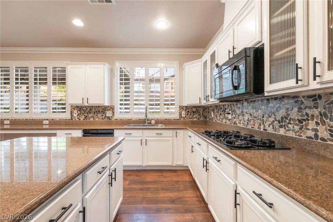 11416 Rancho Portena Avenue, Las Vegas, NV 89138 Rich stone counters and warm wood floors anchor this kitchen with a natural pebble backsplash.