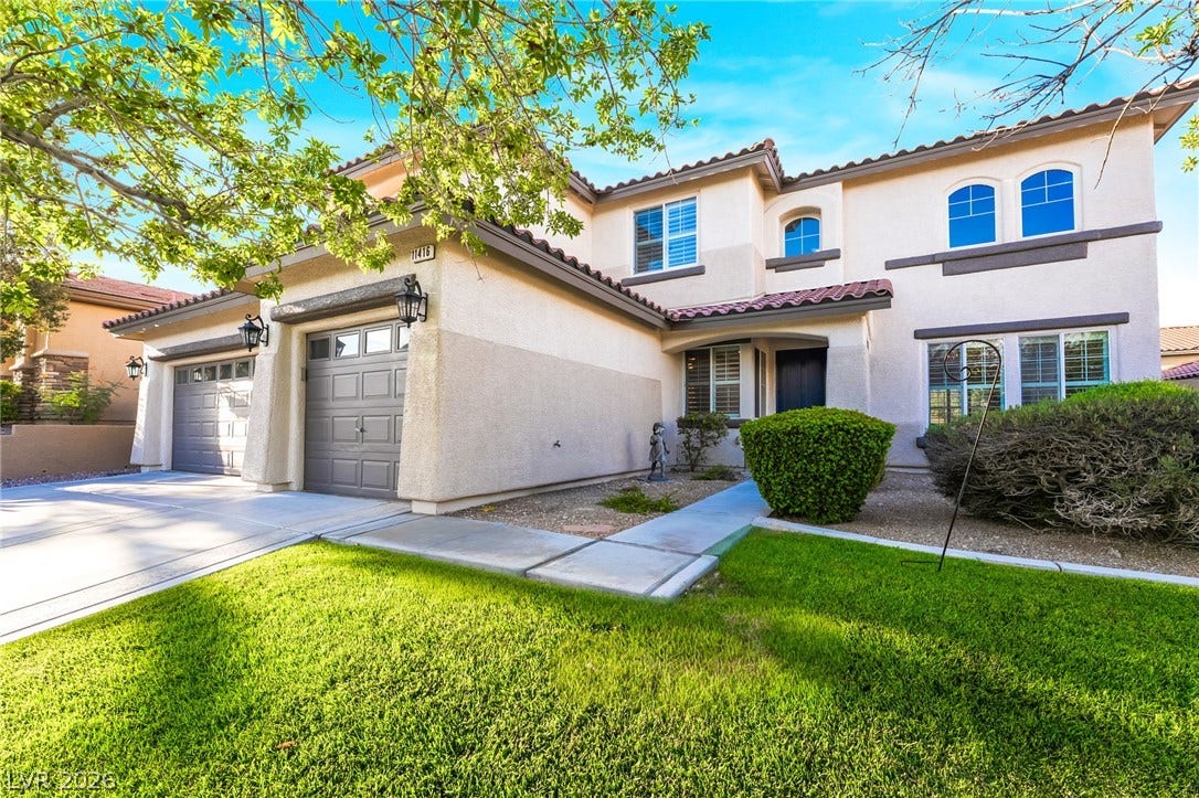 11416 Rancho Portena Avenue, Las Vegas, NV 89138 A classic stucco exterior features arched windows and a tiled roof above manicured green lawns.