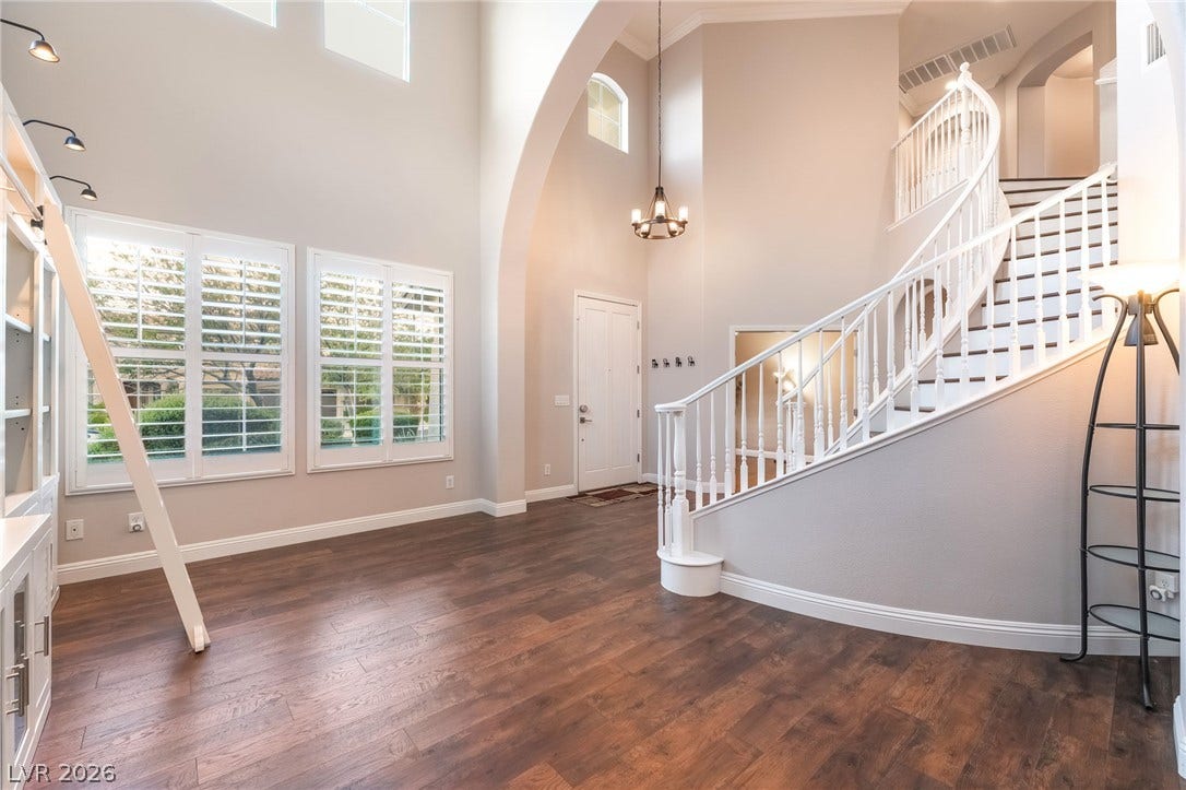 11416 Rancho Portena Avenue, Las Vegas, NV 89138 An elegant curved staircase anchors this soaring entryway detailed with rich wood flooring.