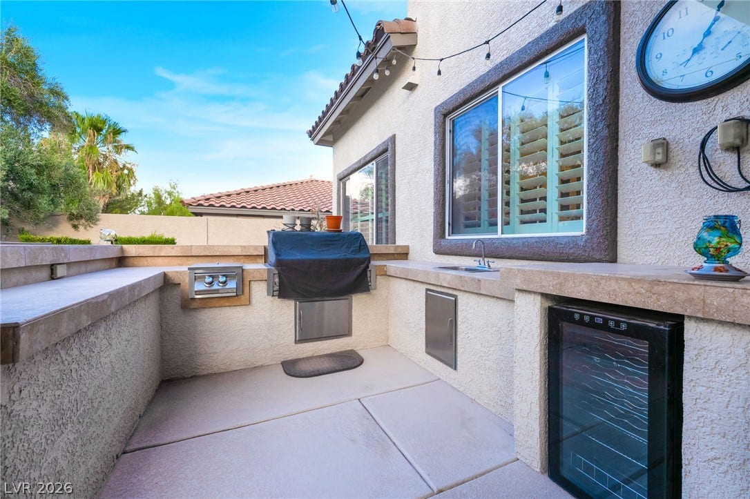 11416 Rancho Portena Avenue, Las Vegas, NV 89138 An integrated outdoor kitchen features stucco finishes and stone countertops under clear desert skies.