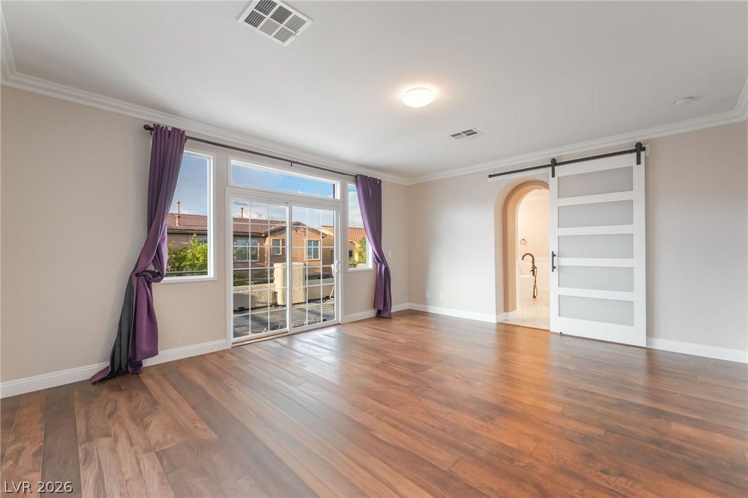 11416 Rancho Portena Avenue, Las Vegas, NV 89138 Rich wood flooring and crown molding define this open room with large sliding doors.