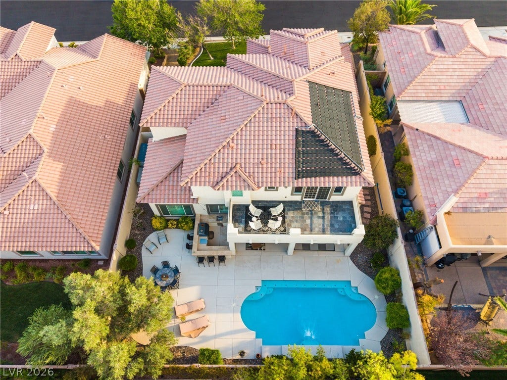 11416 Rancho Portena Avenue, Las Vegas, NV 89138 An aerial perspective reveals a sparkling swimming pool, tiled patio, and elegant clay tile roof.