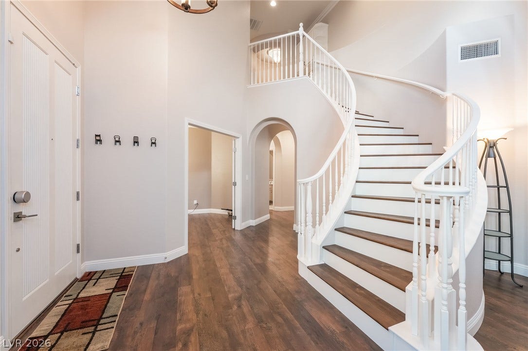 11416 Rancho Portena Avenue, Las Vegas, NV 89138 Rich hardwood flooring complements the graceful curves of a grand floating staircase.