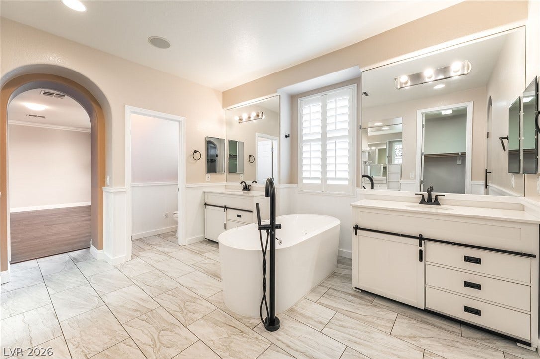 11416 Rancho Portena Avenue, Las Vegas, NV 89138 An elegant freestanding soaking tub anchors this beautifully finished, tile-floored primary bath.