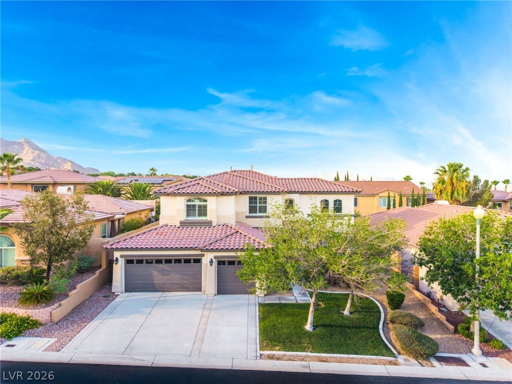 11416 Rancho Portena Avenue, Las Vegas, NV 89138 Spanish tile roofing and a concrete driveway define this multi-level home under clear desert skies.