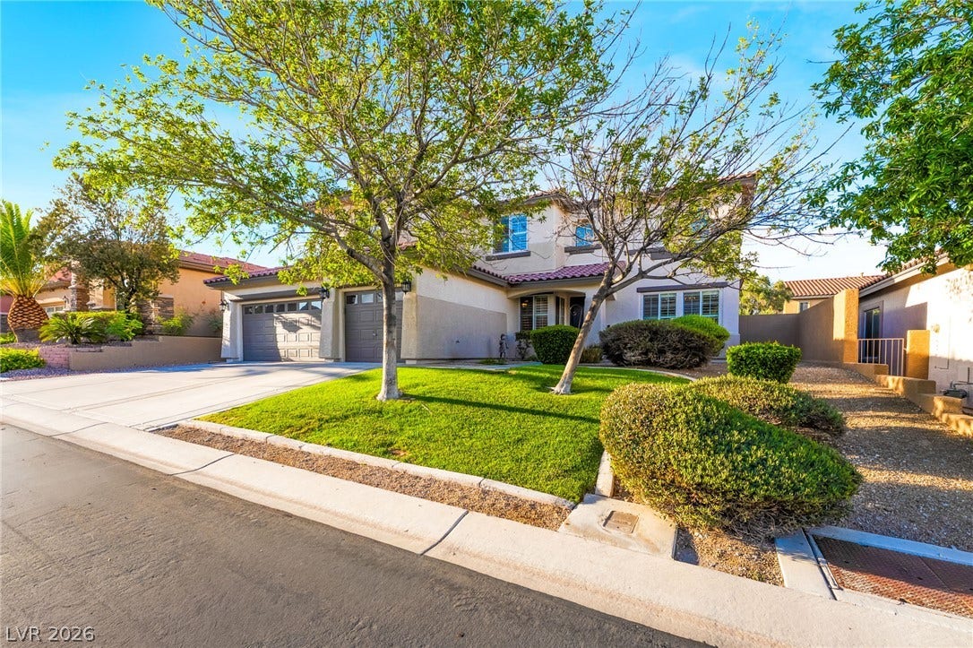 11416 Rancho Portena Avenue, Las Vegas, NV 89138 Mature trees and neat landscaping frame a classic two-story exterior with a multi-car garage.