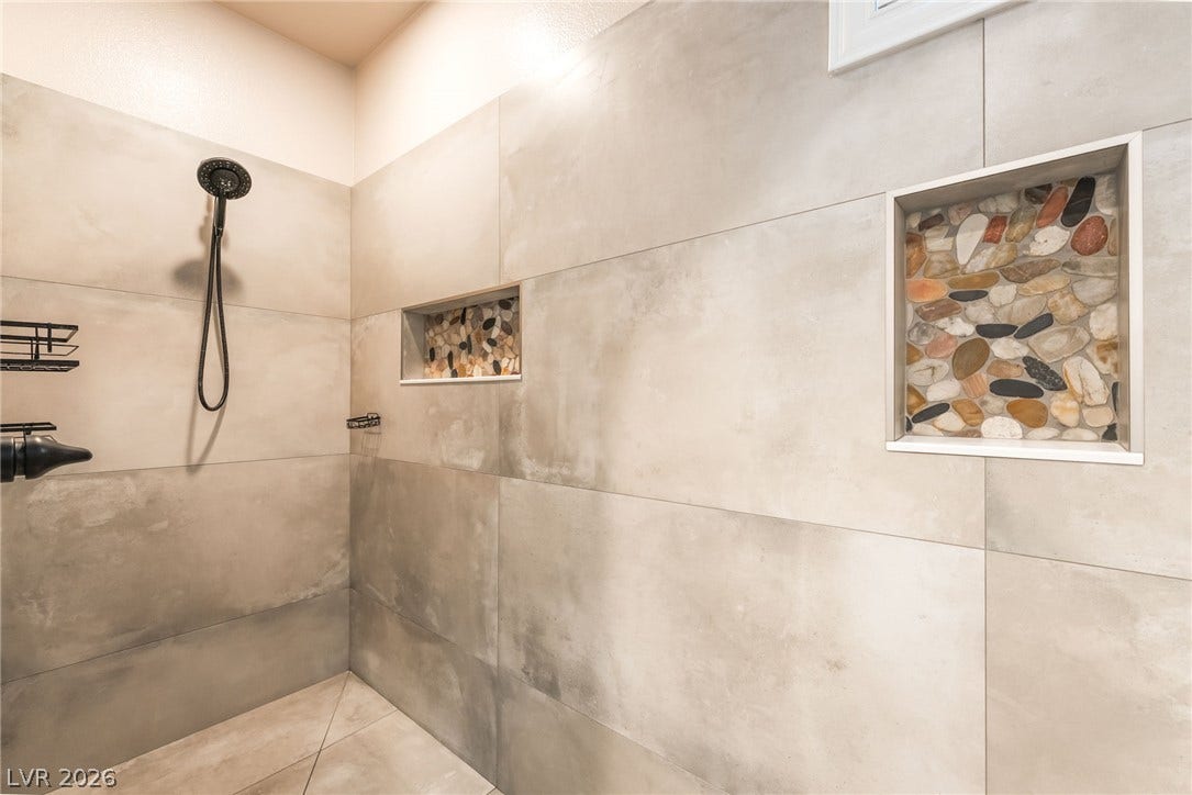 11416 Rancho Portena Avenue, Las Vegas, NV 89138 Large format tiling and built-in stone niches define this modern walk-in shower.