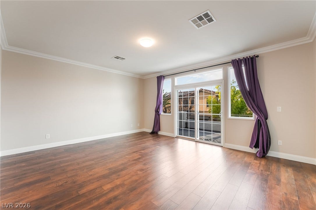 11416 Rancho Portena Avenue, Las Vegas, NV 89138 Rich wood flooring and classic crown molding elevate this open room leading outdoors.