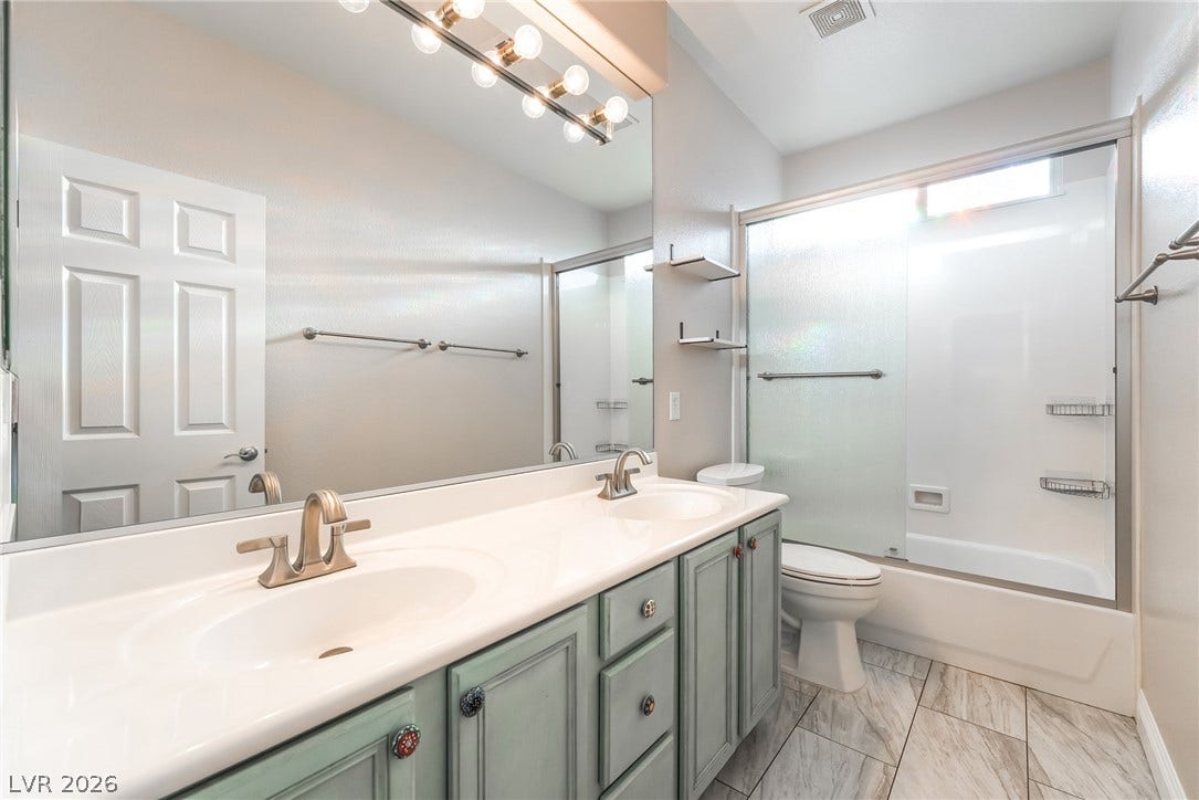 11416 Rancho Portena Avenue, Las Vegas, NV 89138 Double vanity sinks and patterned tile flooring highlight this functional secondary bathroom.