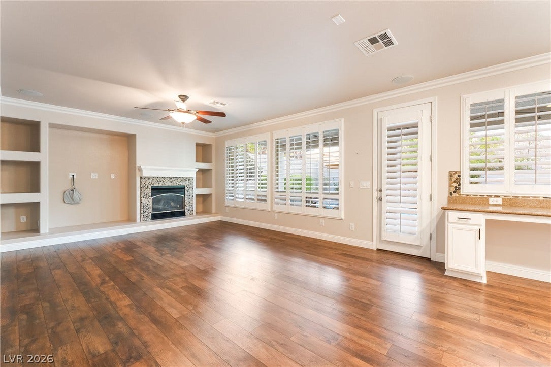 11416 Rancho Portena Avenue, Las Vegas, NV 89138 Rich hardwood floors and a fireplace with custom built-ins define this airy living space.
