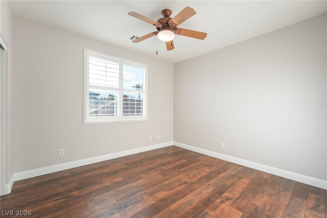 11416 Rancho Portena Avenue, Las Vegas, NV 89138 Rich wood-inspired flooring and classic plantation shutters highlight this versatile secondary bedroom space.