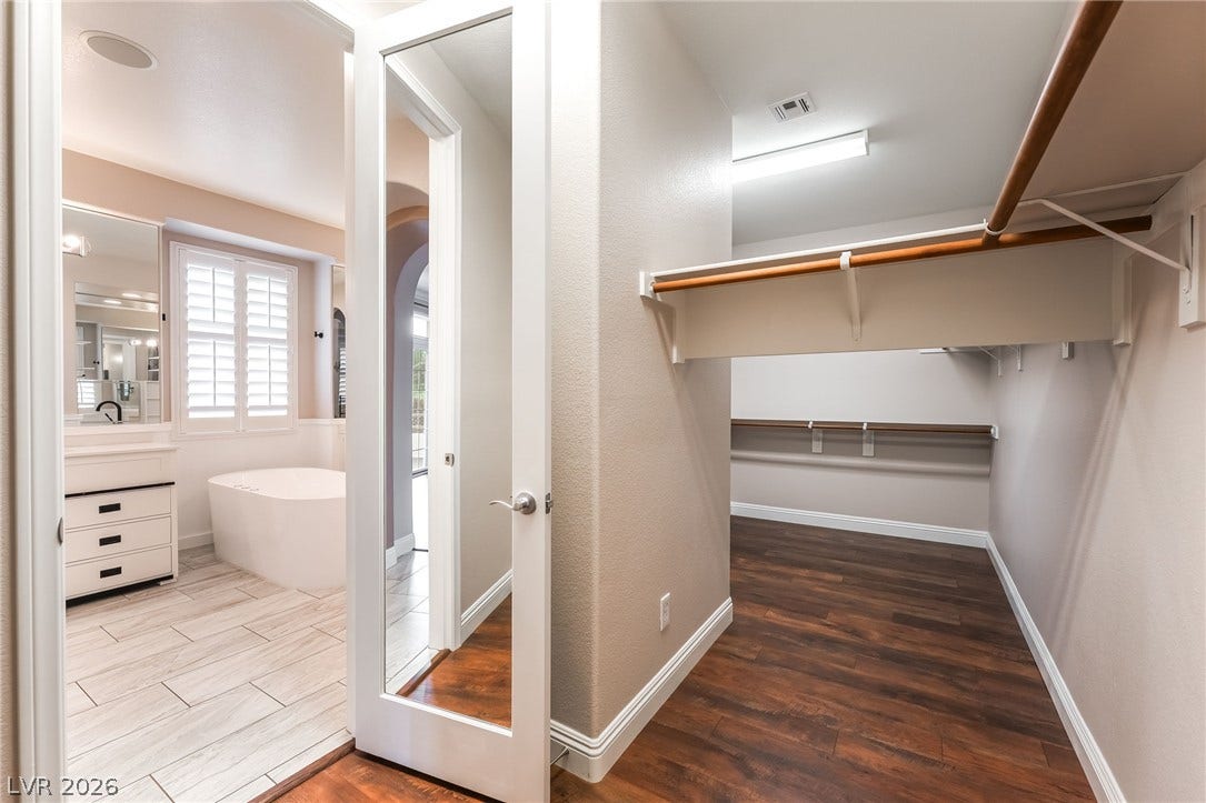 11416 Rancho Portena Avenue, Las Vegas, NV 89138 Rich wood floors and built-in shelving define this large walk-in closet adjacent to the bath.