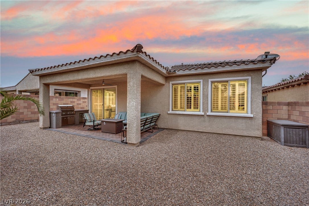 An inviting covered patio featuring an outdoor kitchen and ample space for relaxation.