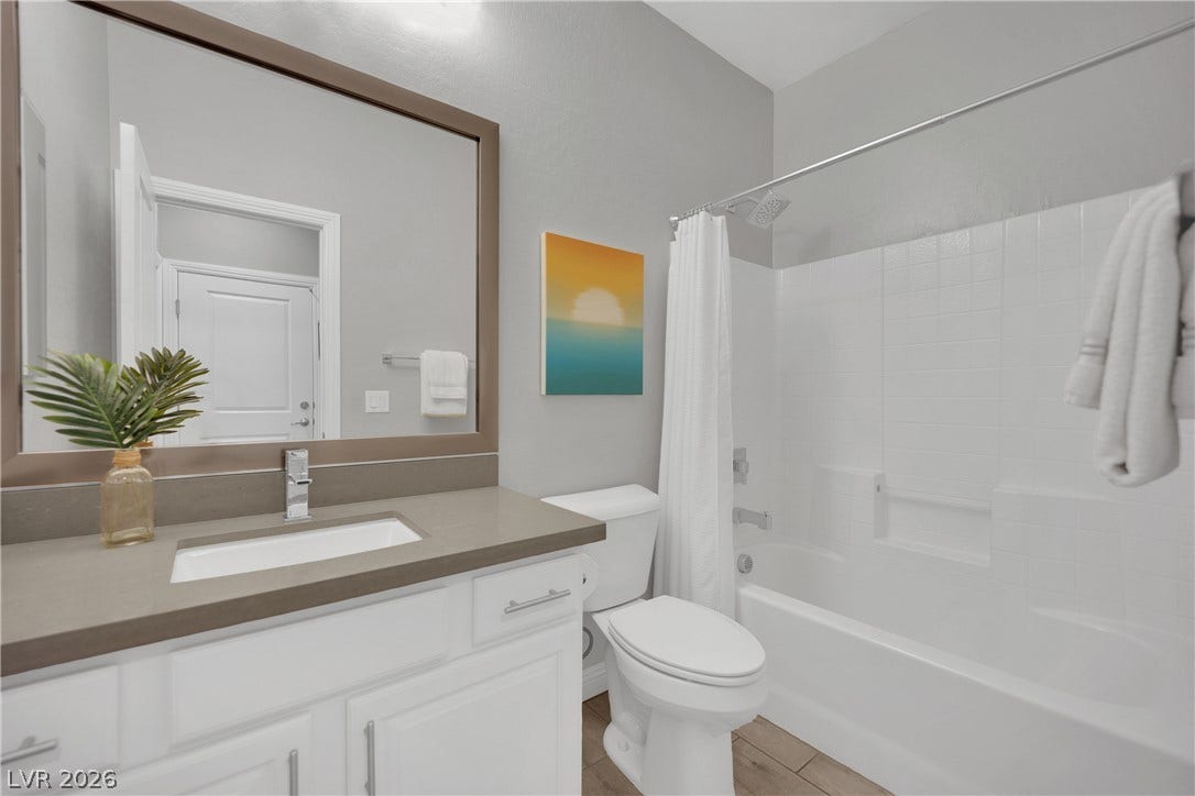 A refined bathroom featuring a sleek vanity with ample counter space and a modern tub-shower combination.