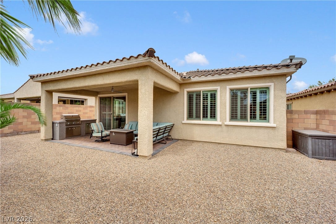 A private outdoor haven features a built-in barbecue and a shaded patio, perfect for alfresco dining.