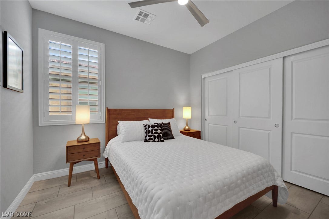 Relax in this well-lit bedroom featuring a spacious closet and elegant tile flooring.