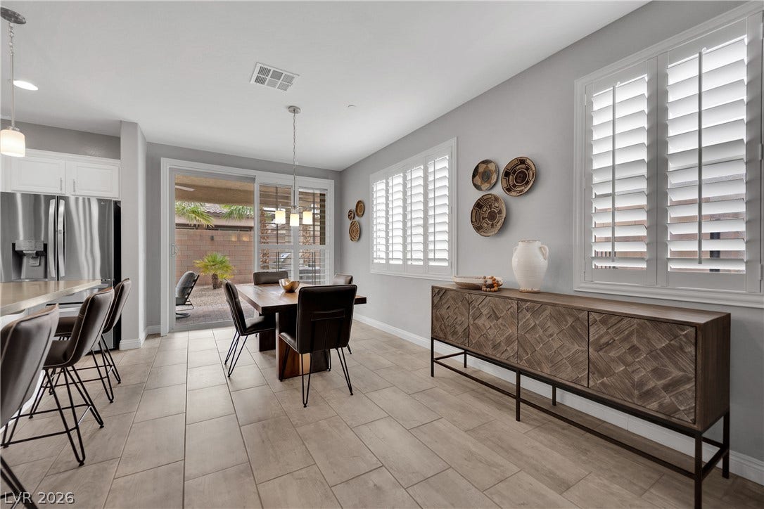 This naturally illuminated eat-in kitchen features a sleek dining area and convenient outdoor access.