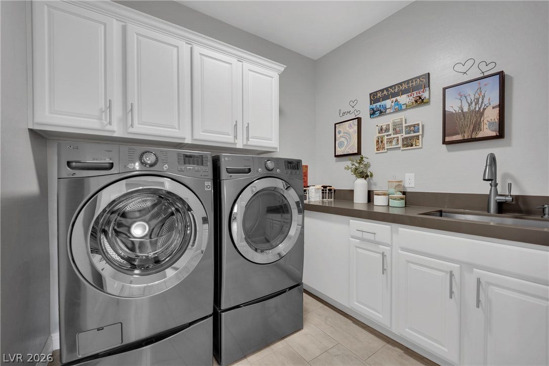 Functional laundry room offers upper cabinetry, sink, and countertop space for daily tasks.