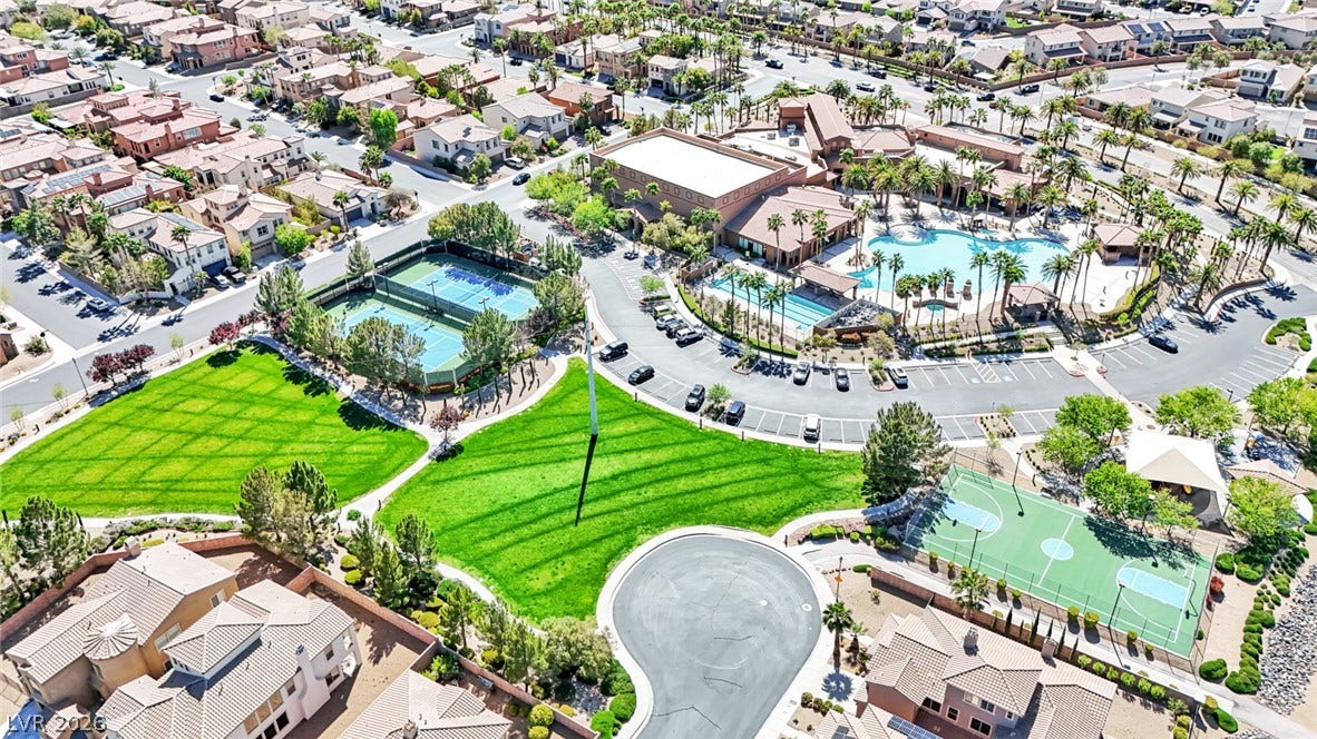 An aerial panorama showcases a master-planned community with lush golf courses, serene water features, and expansive mountain vistas.