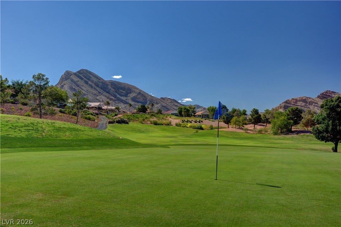 2621 Hanging Rock Drive, Las Vegas, NV 89134 Lush fairways frame majestic mountain peaks under a clear blue desert sky.