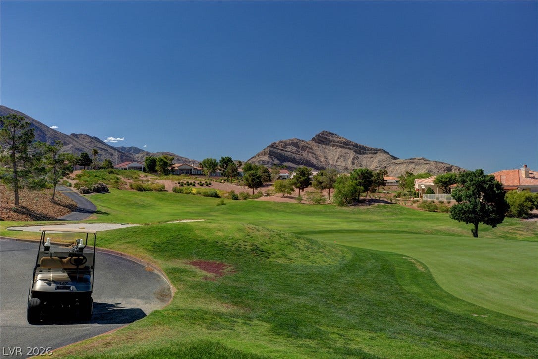 2621 Hanging Rock Drive, Las Vegas, NV 89134 Lush fairways stretch toward dramatic mountain backdrops under clear desert skies.