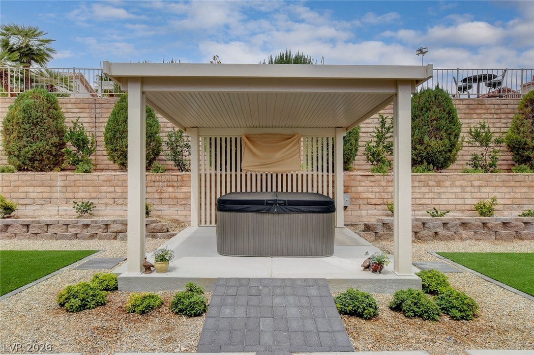2621 Hanging Rock Drive, Las Vegas, NV 89134 A private covered structure shelters a modern spa alongside meticulously tiered stone retaining walls.