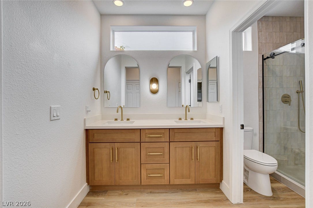 2621 Hanging Rock Drive, Las Vegas, NV 89134 A wooden double vanity pairs with wood-look flooring under a bright clerestory window.