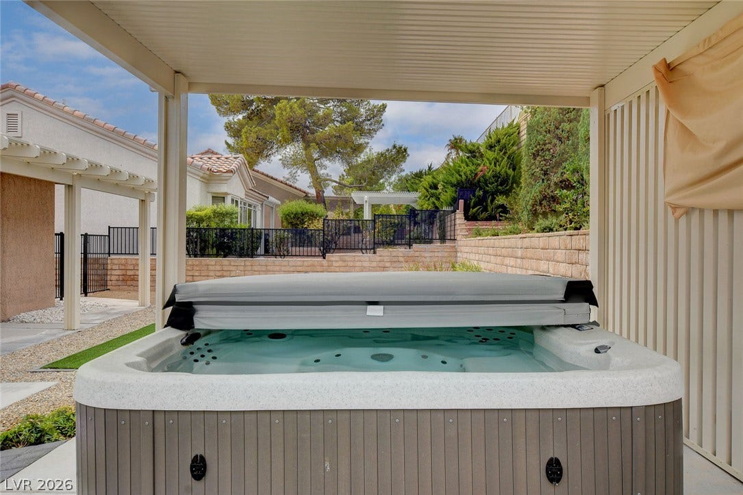 2621 Hanging Rock Drive, Las Vegas, NV 89134 A sheltered outdoor spa sits on a paved patio overlooking a terraced yard.