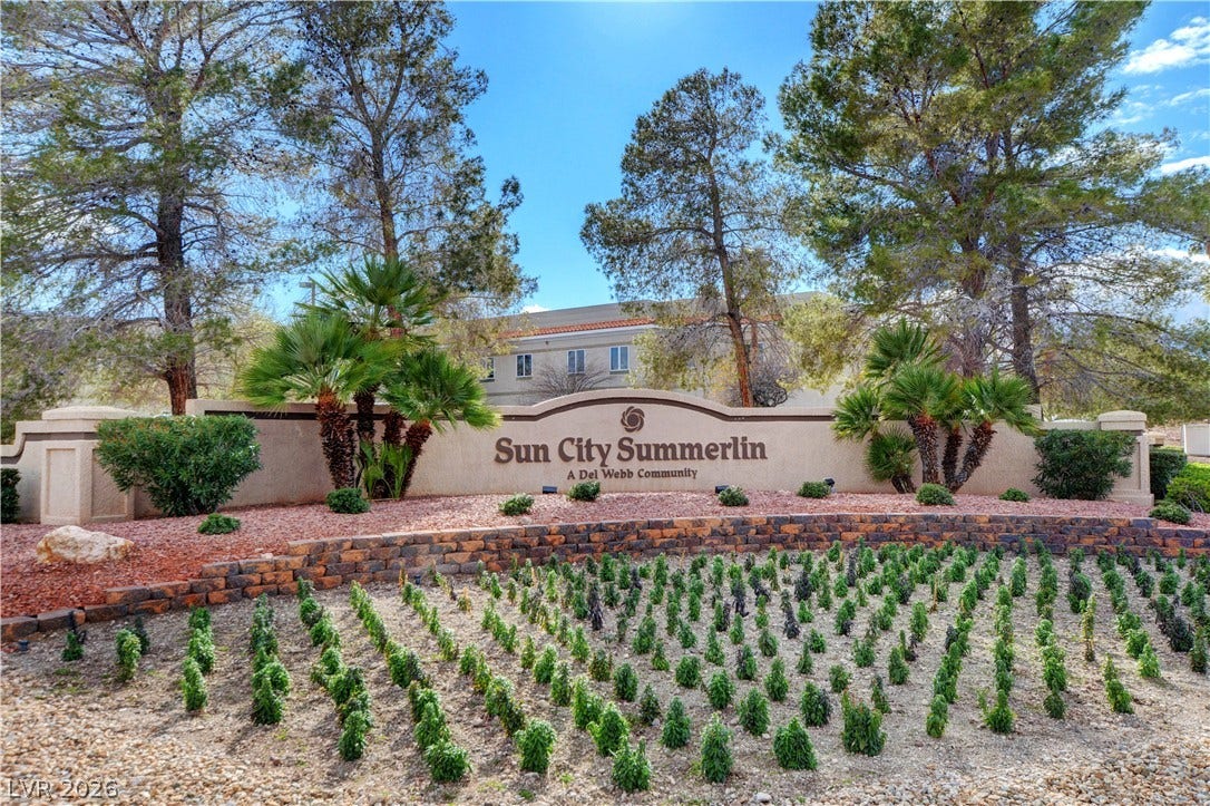 2621 Hanging Rock Drive, Las Vegas, NV 89134 Mature trees and neat desert landscaping frame the stone entry sign to the community.