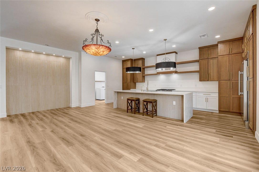 2621 Hanging Rock Drive, Las Vegas, NV 89134 Warm wood tones and clean architectural lines define this open-plan kitchen and dining area.