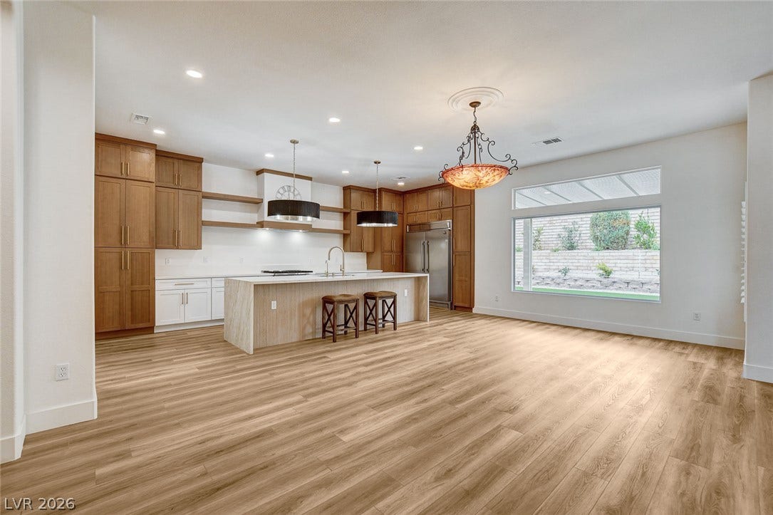 2621 Hanging Rock Drive, Las Vegas, NV 89134 Warm wood flooring and extensive cabinetry define this open kitchen and dining area.
