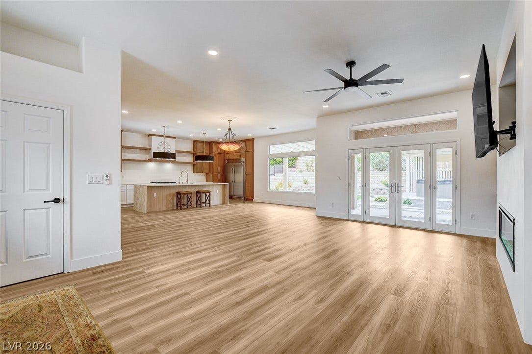 2621 Hanging Rock Drive, Las Vegas, NV 89134 Warm wood flooring and glass doors highlight this inviting open-concept living space.