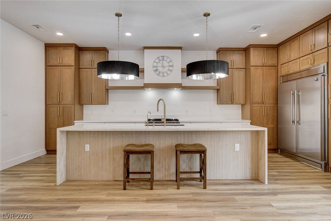 2621 Hanging Rock Drive, Las Vegas, NV 89134 Gleaming wood floors anchor a culinary workspace defined by warm cabinetry and stone counters.