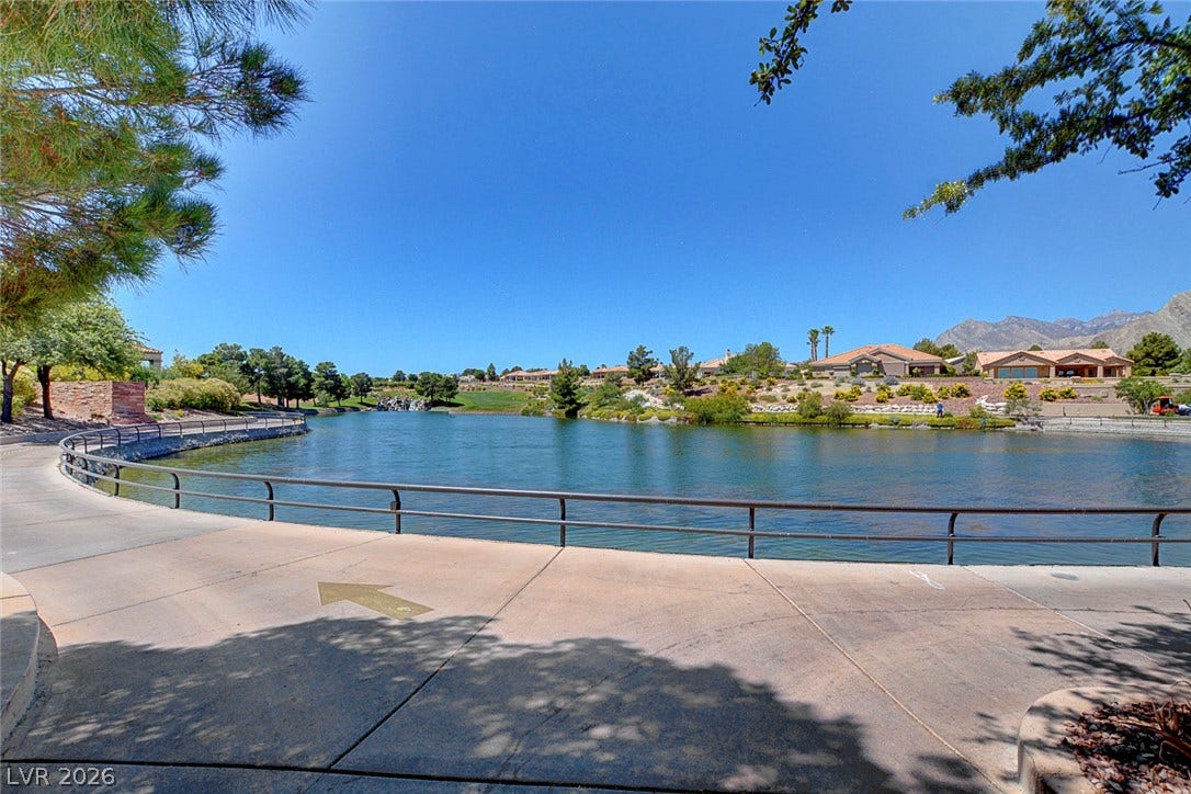 2621 Hanging Rock Drive, Las Vegas, NV 89134 A paved path traces the edge of a scenic community lake beneath open blue skies.