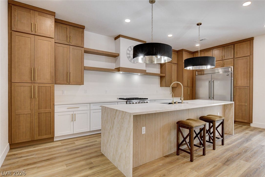 2621 Hanging Rock Drive, Las Vegas, NV 89134 Rich wood cabinetry and a central stone island define this culinary space.
