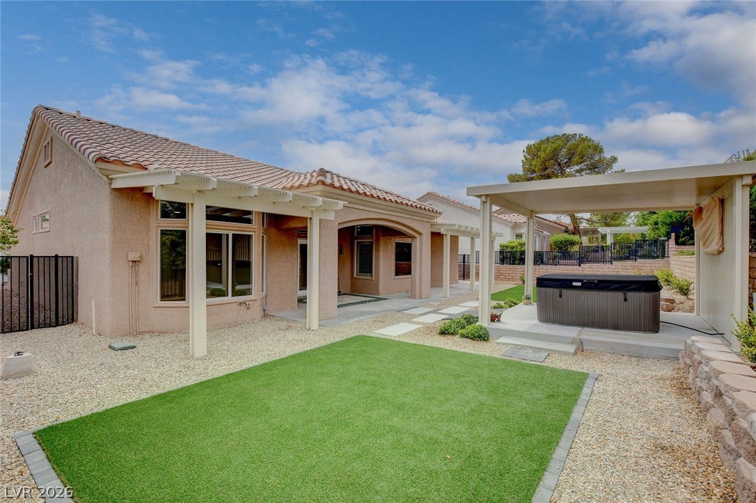2621 Hanging Rock Drive, Las Vegas, NV 89134 An inviting backyard features a pristine lawn area alongside covered patio spaces.