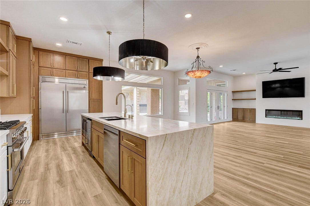2621 Hanging Rock Drive, Las Vegas, NV 89134 Warm wood cabinetry and durable hard surface flooring enrich this integrated open-concept kitchen.