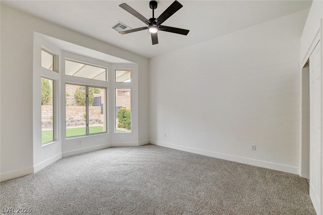 2621 Hanging Rock Drive, Las Vegas, NV 89134 Plush carpeting and a dramatic bay window frame views of the rear yard.