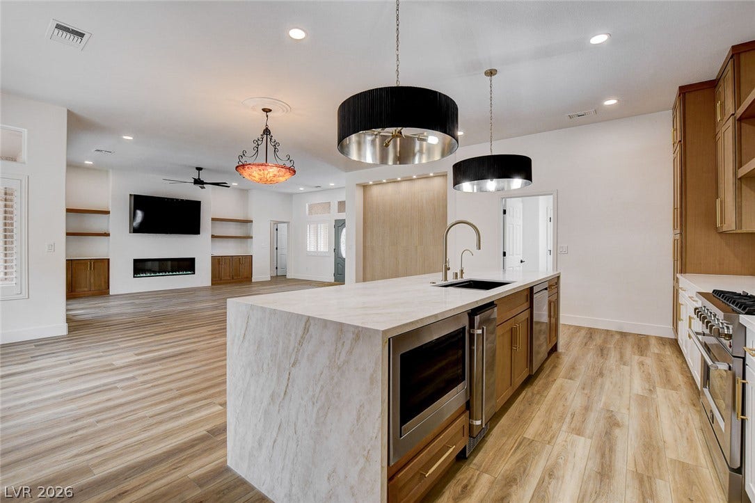 2621 Hanging Rock Drive, Las Vegas, NV 89134 An open-concept kitchen with a waterfall island flows into a living space with hardwood flooring.