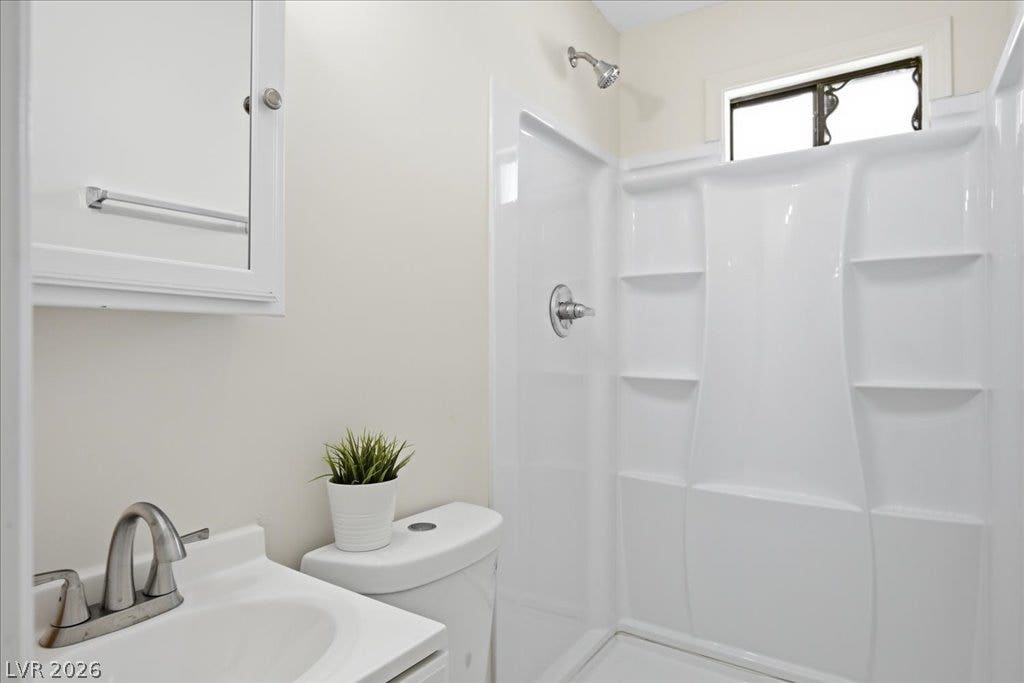 3912 Casa Grande Avenue, Las Vegas, NV 89102 A streamlined modern bathroom features a white vanity set against clean, minimalist walls.