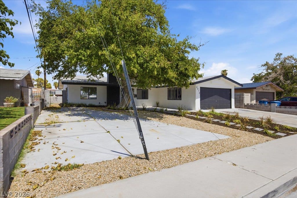 3912 Casa Grande Avenue, Las Vegas, NV 89102 Clean lines and a spacious driveway define this modern single-story residence with a mature shade tree.